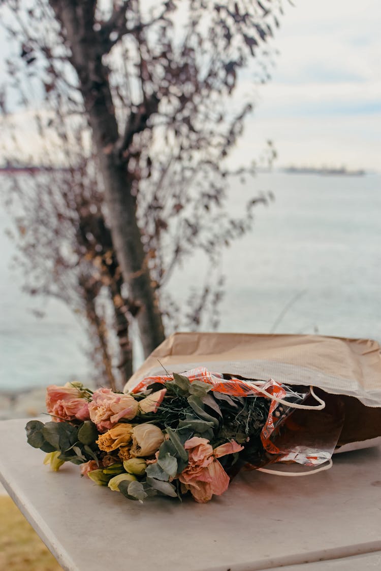 A Bunch Of Flowers Inside The Paper Bag On The Table