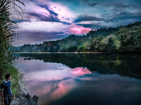 厄瓜多尔郁郁葱葱的雨林中，日落时宁静的河景映照着充满活力的天空