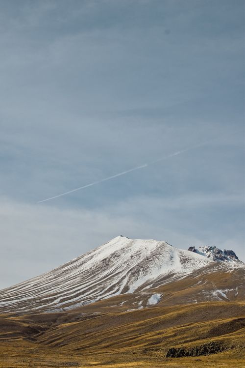 Free Serene snowcapped mountain under a clear sky, perfect for nature enthusiasts and landscape photography lovers. Stock Photo