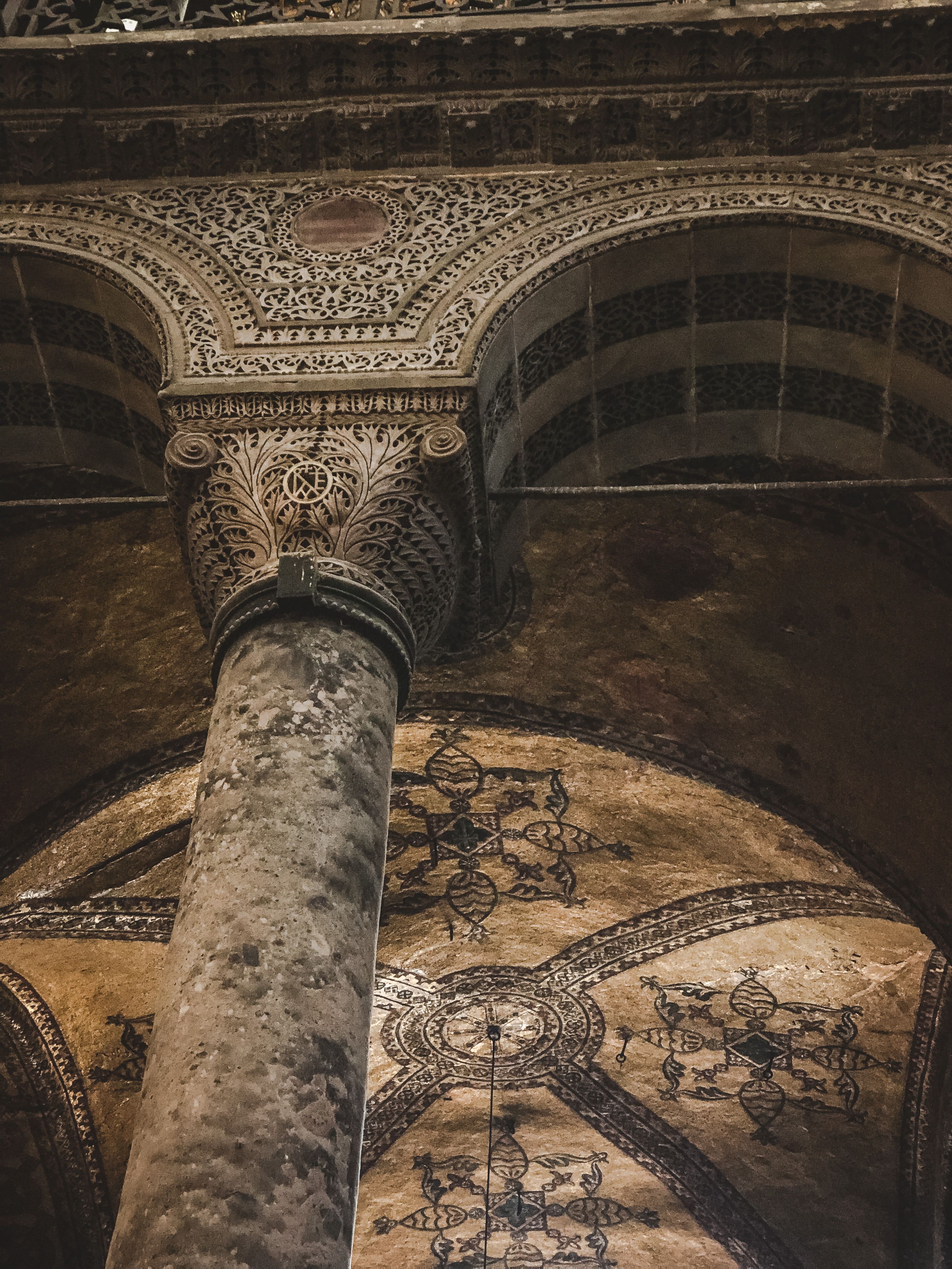 Beautiful low-angle view of ornate arches and columns in a mosque, showcasing Islamic art.