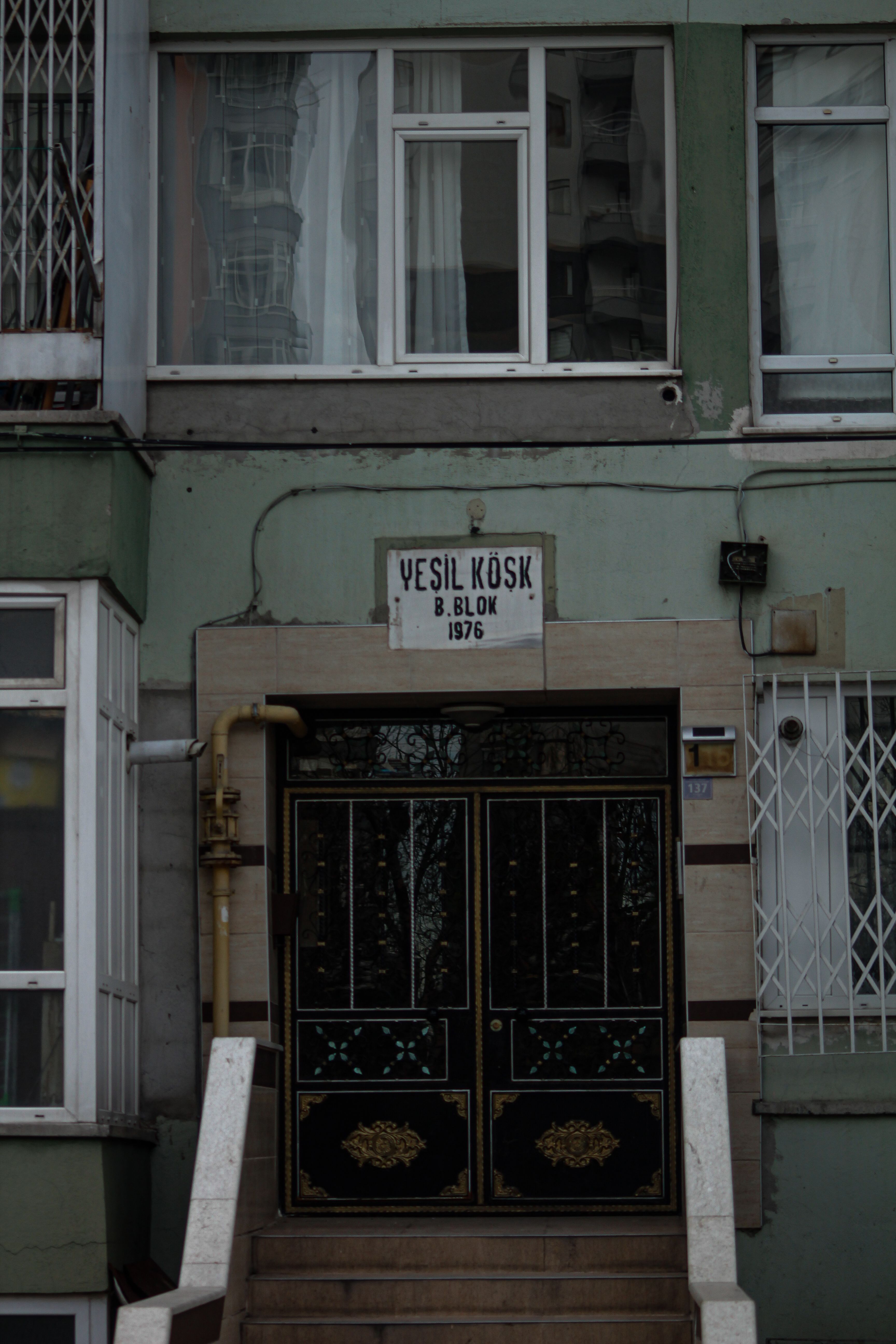 Vertical shot of Yeşil Köşk building entrance in urban street setting.