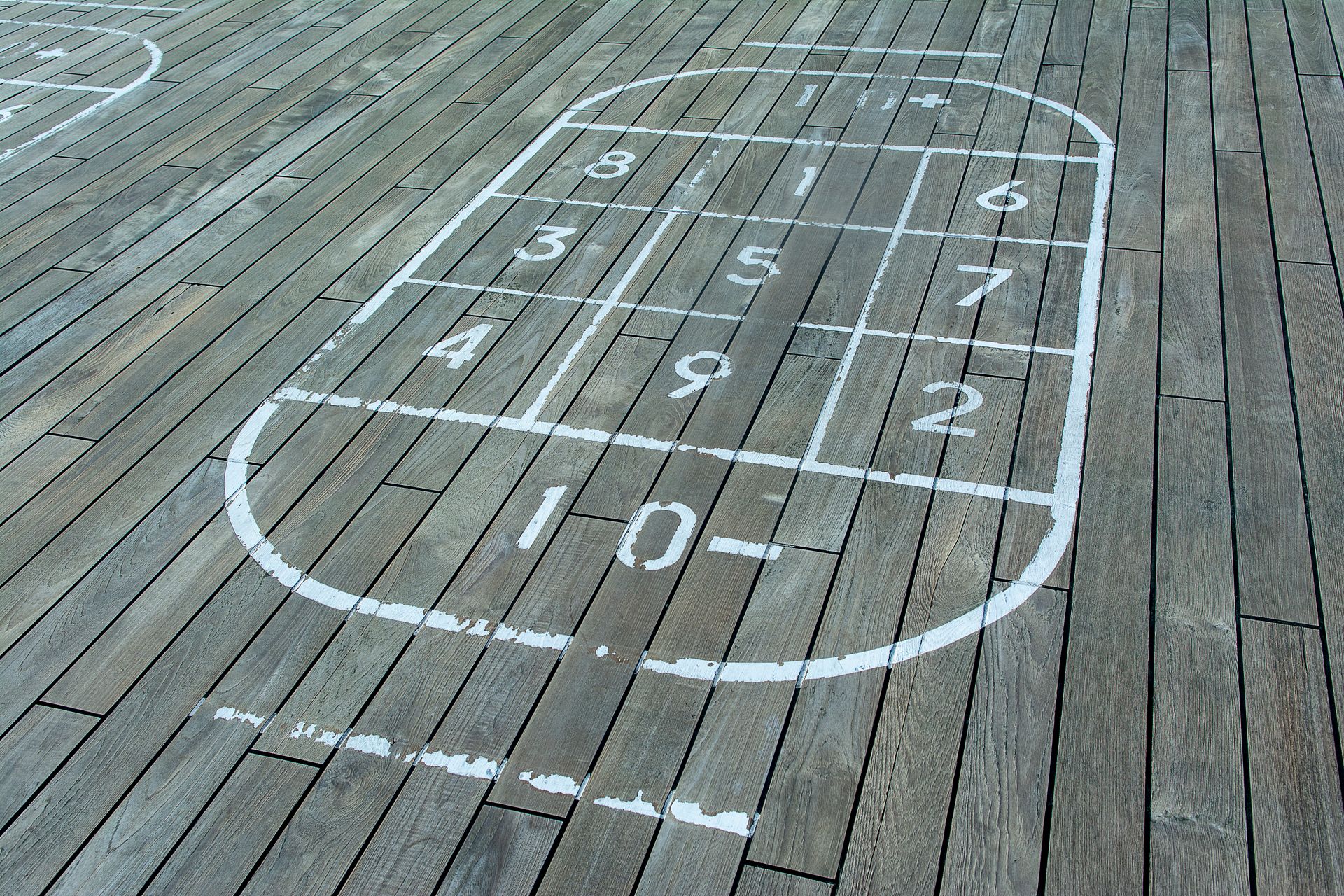Outdoor shuffleboard court on wooden panels with numbered grid pattern for recreation and entertainment