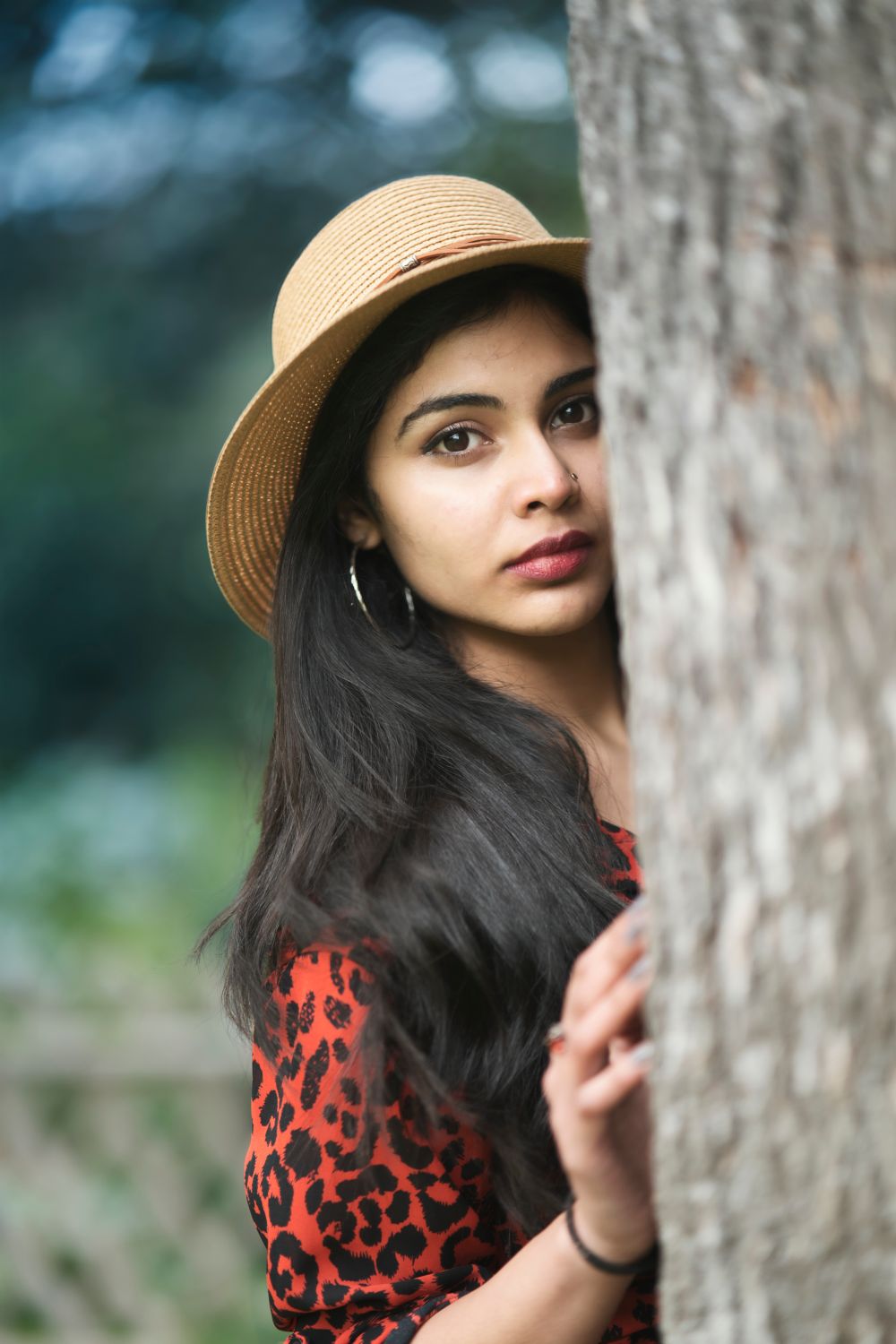 A Woman Standing Beside Brown Tree Trunk · Free Stock Photo