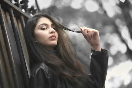 A Woman in Black Leather Jacket Holding Her Hair