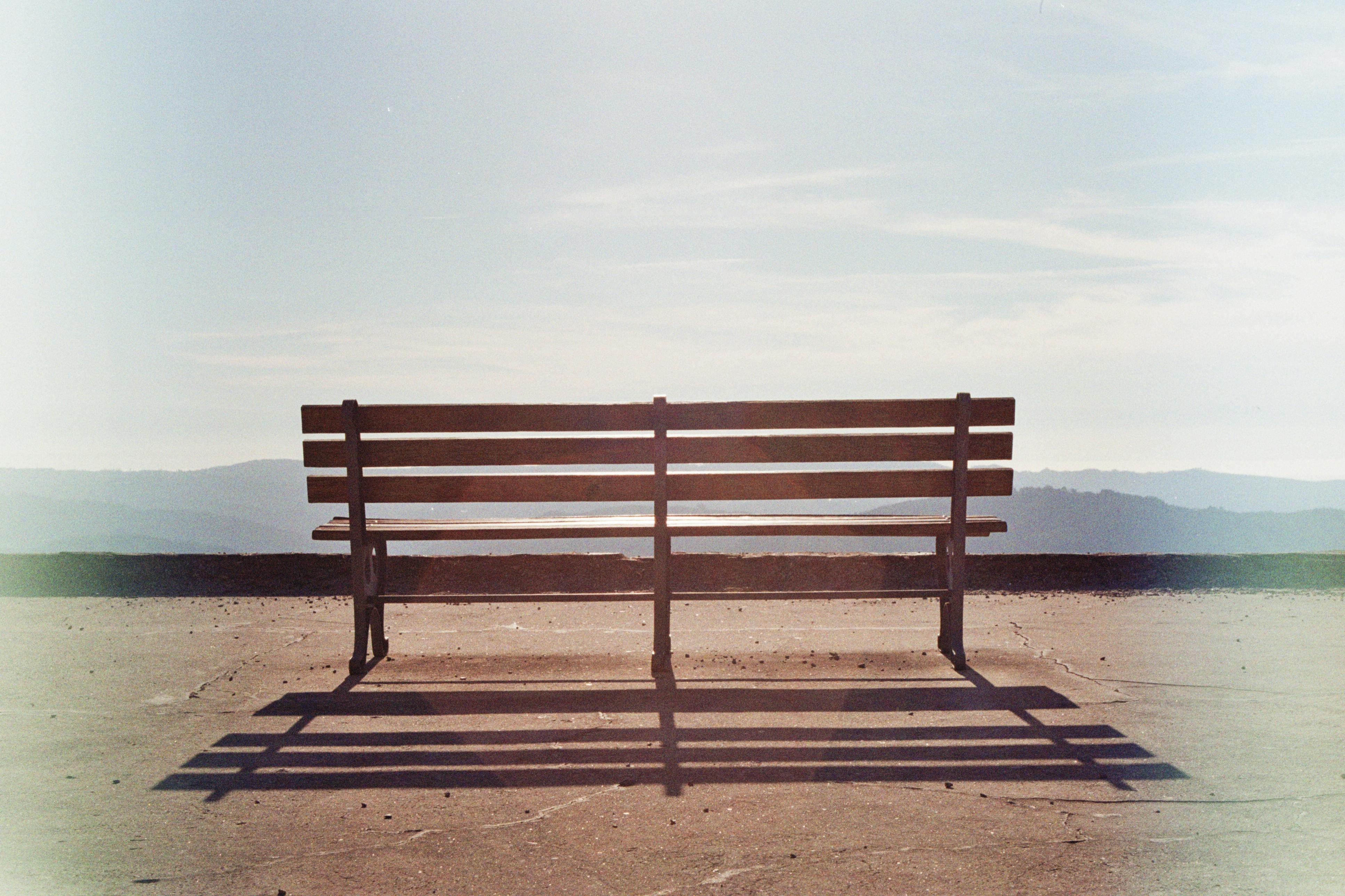 A lone wooden bench on a terrace in Arouca, Portugal, with a vast mountain view.