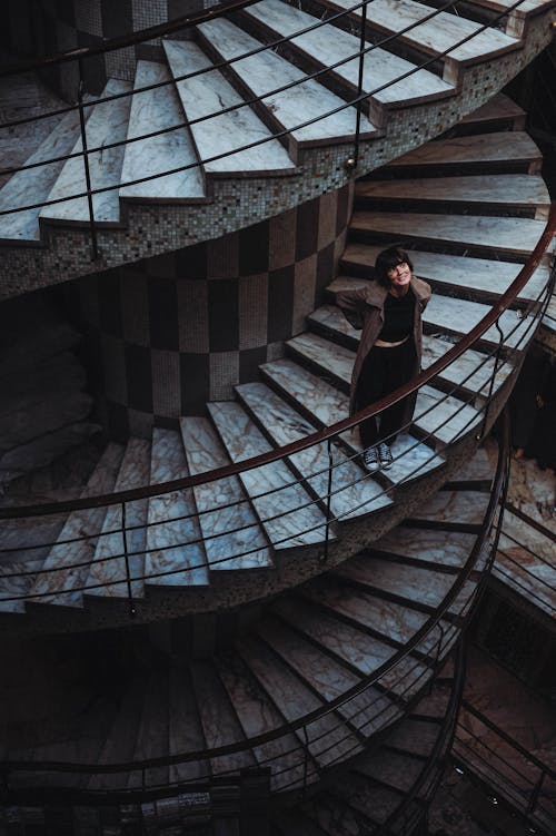Woman Standing on Swirling Staircase