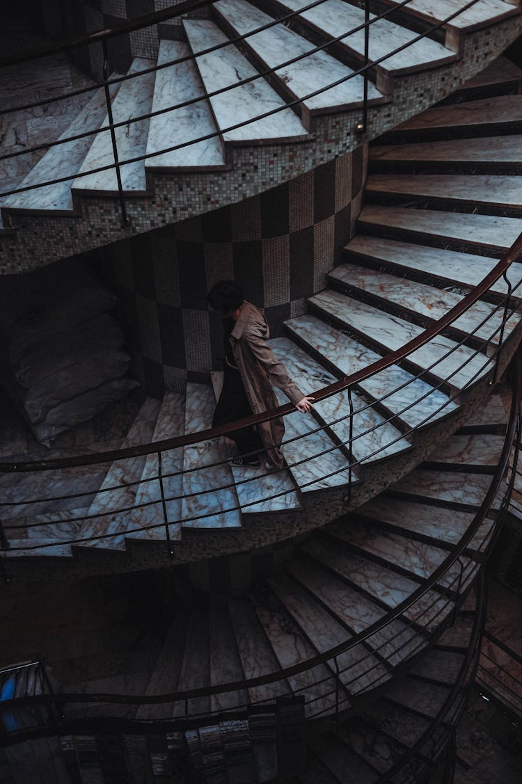 Woman Walking Down Swirling Staircase