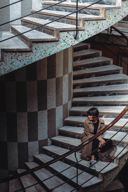 Woman Sitting on Spiral Staircase