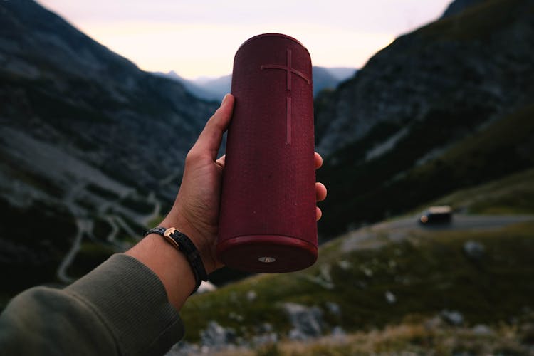 Photo Of A Person's Hand Holding A Red Speaker