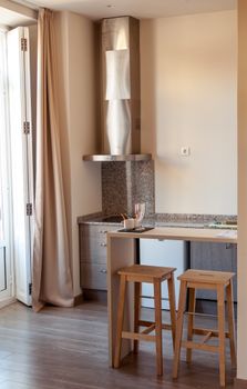 Elegant kitchen interior featuring a modern bar counter with wooden stools and granite surfaces.