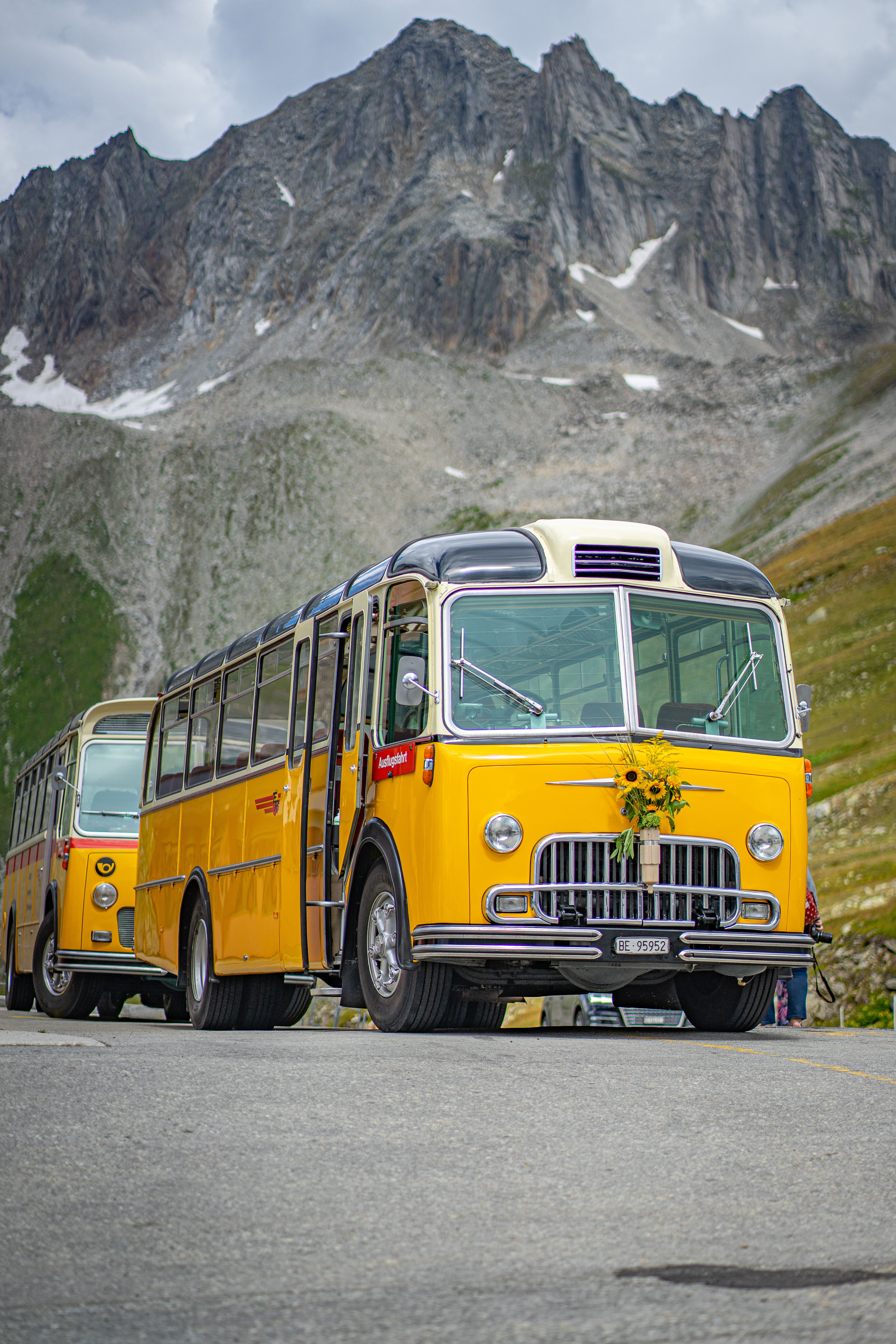 Vintage gele bus in de Franse Alpen met bergen, levendige reis scène.