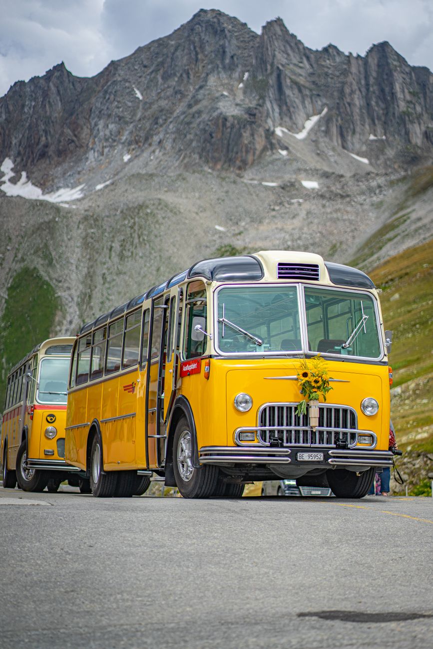 Vintage gele bus in de Franse Alpen met bergen, levendige reis scène.