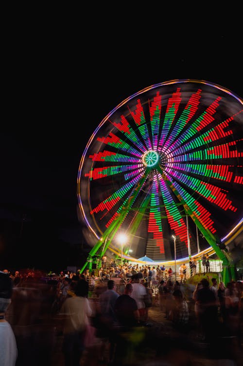 Crowd at a Festival by an Illuminated Ferris Wheel 