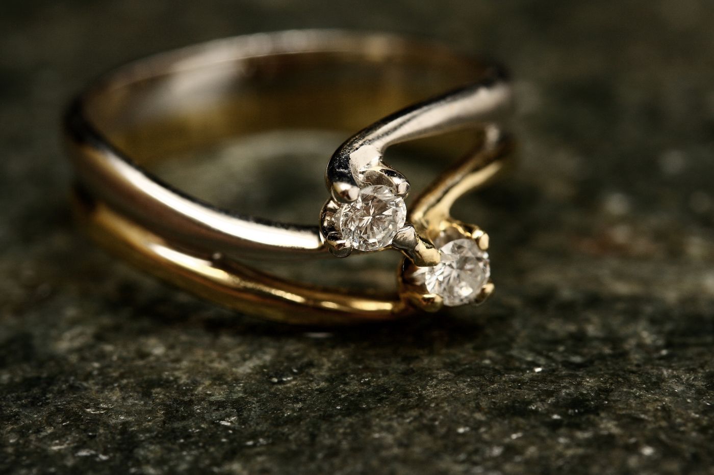 Anillo de oro con diamante en macro sobre fondo oscuro