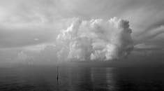 宁静的海面上，单色云景展现了引人注目的云层，非常适合用作壁纸或宁静的艺术品