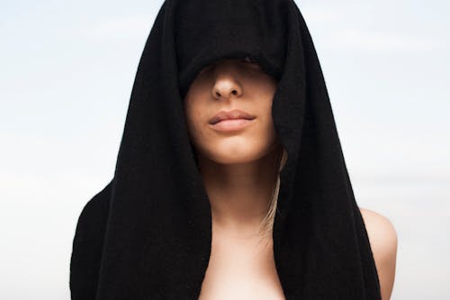用黑色毛巾在她头上的女人的照片