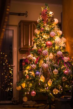 A beautifully decorated Christmas tree with vibrant lights and ornaments indoors.