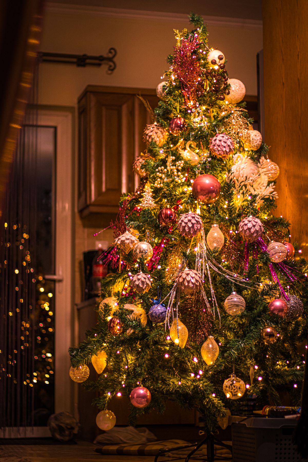 Christmas tree with vibrant multi-colour lights and ornaments indoors