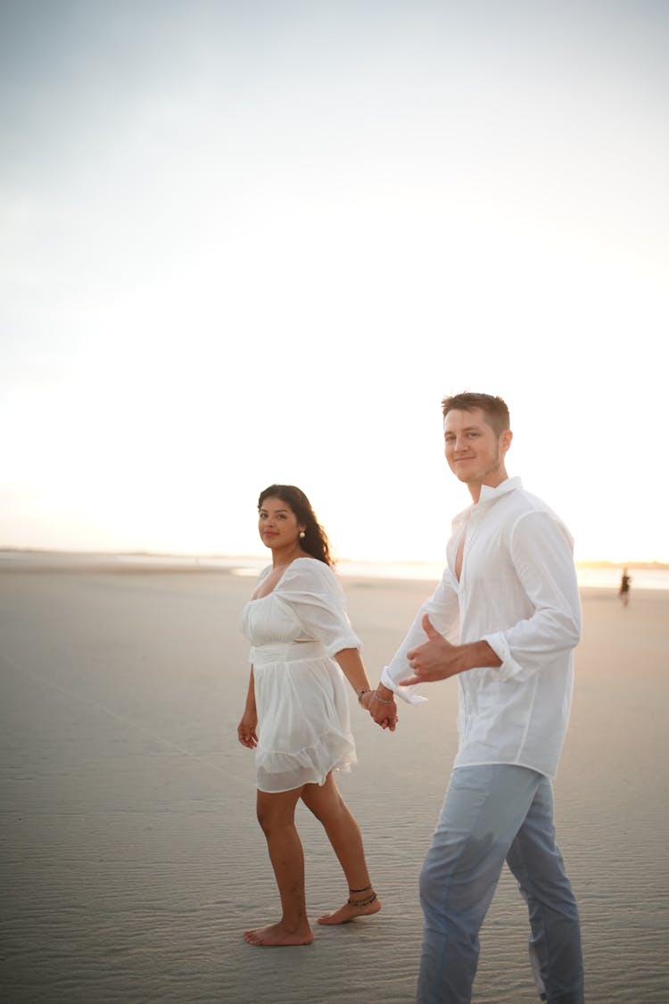 A Couple Walking On Sand