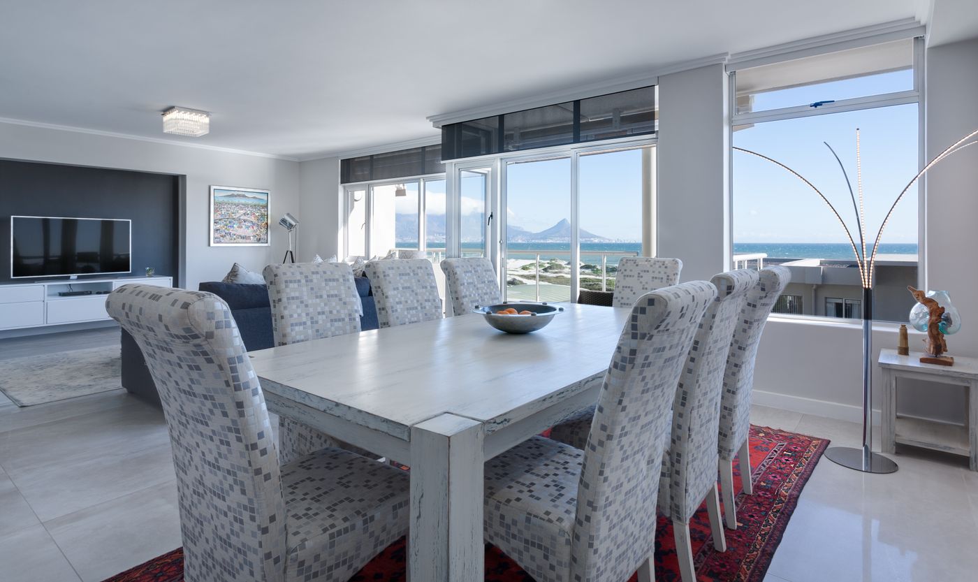 ocean-view dining room with white chairs and mountain panorama — architectural photographer Cape Town | ProShoot.io