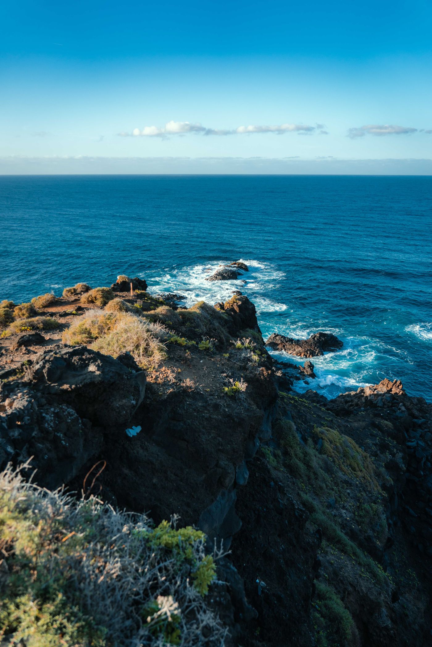 Rugged coastal cliffs meeting the ocean along a scenic coastal drive