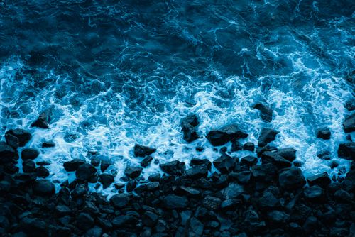 Free Aerial view of ocean waves crashing on rocky shoreline in Puerto de la Cruz, Spain. Stock Photo