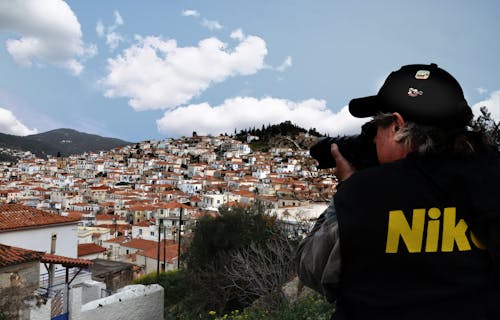 Man Taking Photo of Brown Houses