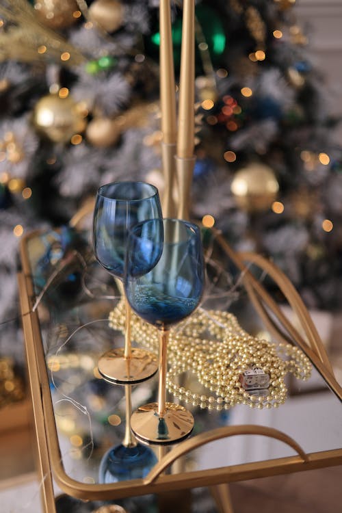 Blue Wineglasses on a Table with a Christmas Tree in the Background