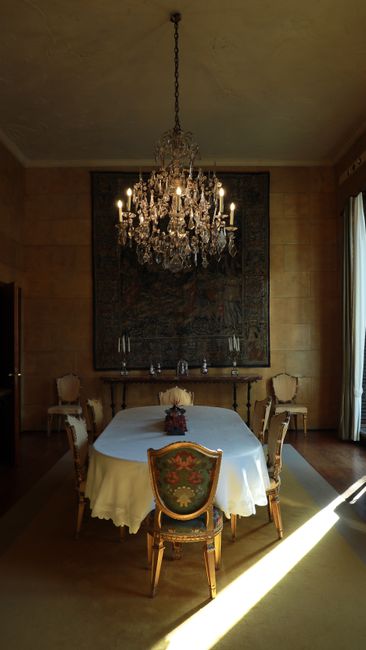 Luxurious dining room in Milan featuring an ornate chandelier and classic interior decor.