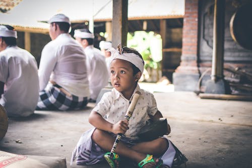 Boy Holding Flute While Sitting on Floor