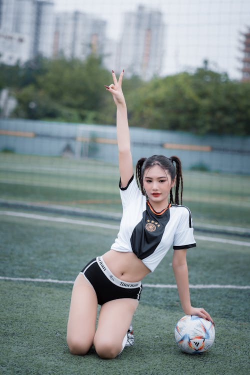 Young Woman in a Skimpy Outfit Posing on a Football Pitch 