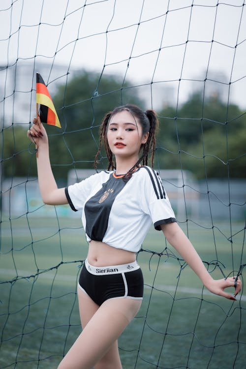 Young Woman in a Skimpy Outfit Posing on a Football Pitch 