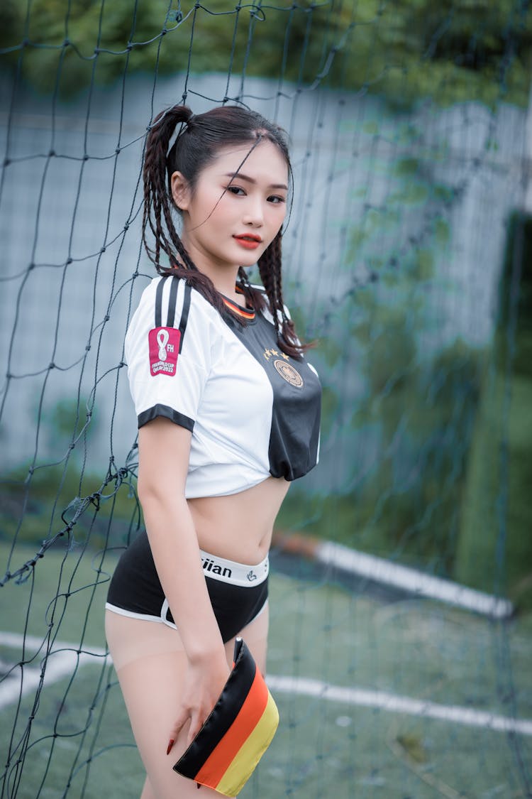 Woman In Football Jersey Standing Beside A Net