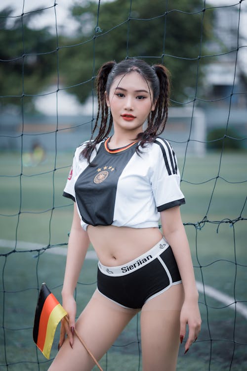 A Young Woman in a Soccer Jersey Holding a German Flag