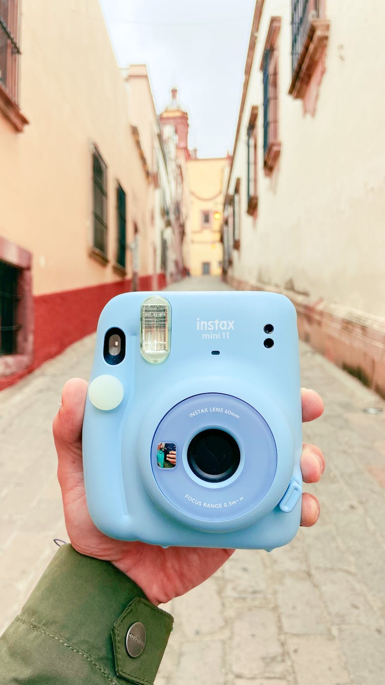 A Person Holding Blue Polaroid Camera