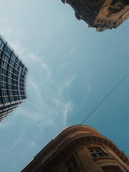 在晴朗的蓝天下，从引人注目的低角度欣赏现代与历史悠久的城市建筑