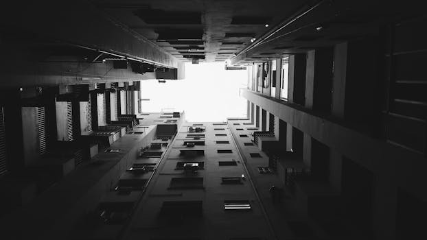 Striking view looking up between urban buildings in monochrome perspective.