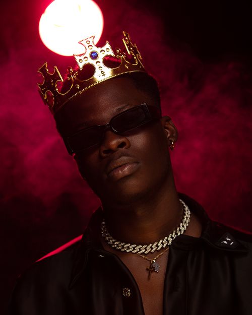 Free Elegant portrait of a man wearing a crown and jewelry with red lighting. Stock Photo
