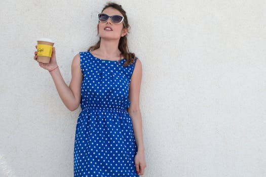 一位身着圆点连衣裙的时尚女士，在阳光明媚的日子里喝着咖啡，尽显无忧无虑的生活方式