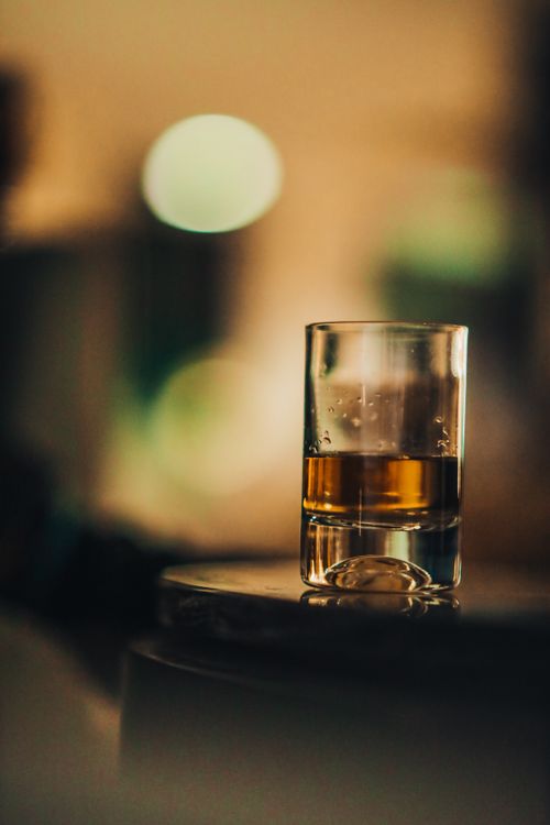 Free A beautifully captured whiskey glass with a bokeh background, showcasing warmth and stillness. Stock Photo