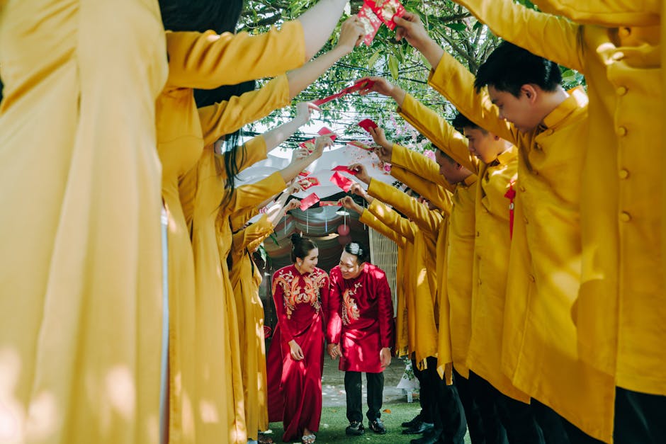 Wedding Couple Wearing Traditional Red Clothing and Row of Guests Dressed in Yellow