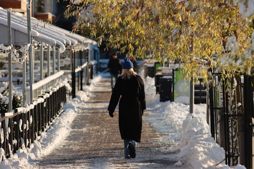 Woman Walking on Sidewalk in Winter