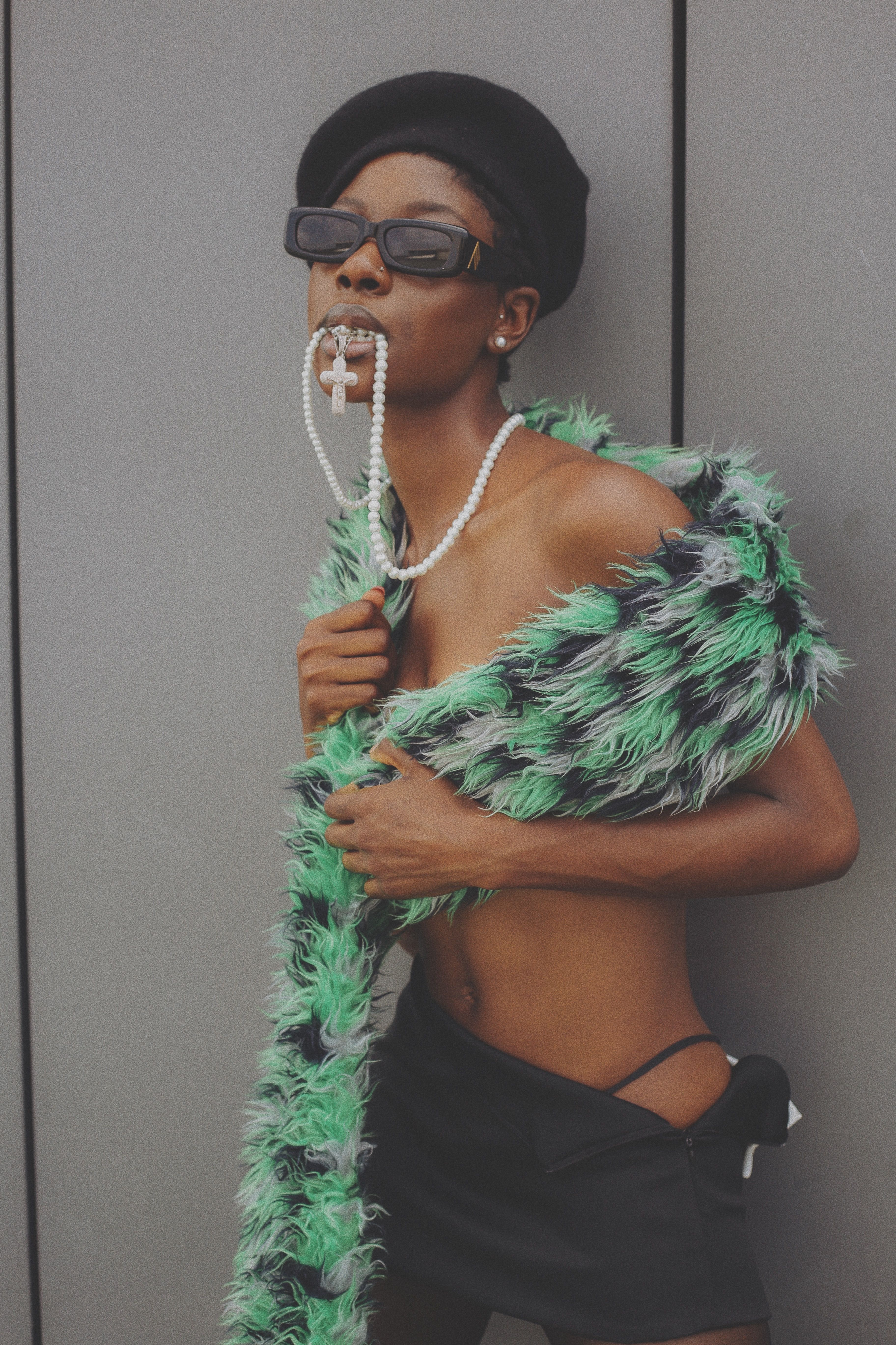 Stylish woman poses in Accra, Ghana, wearing sunglasses and vibrant fur attire.