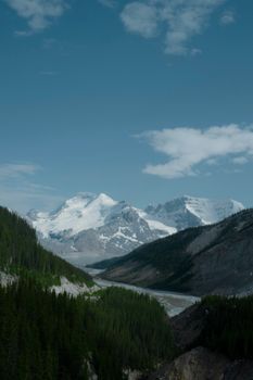 Majestic snowcapped mountains under a clear sky in Jasper National Park, Alberta, Canada.