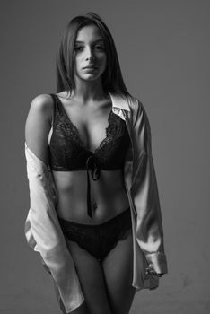 Black and white portrait of a woman in lingerie with an open shirt.