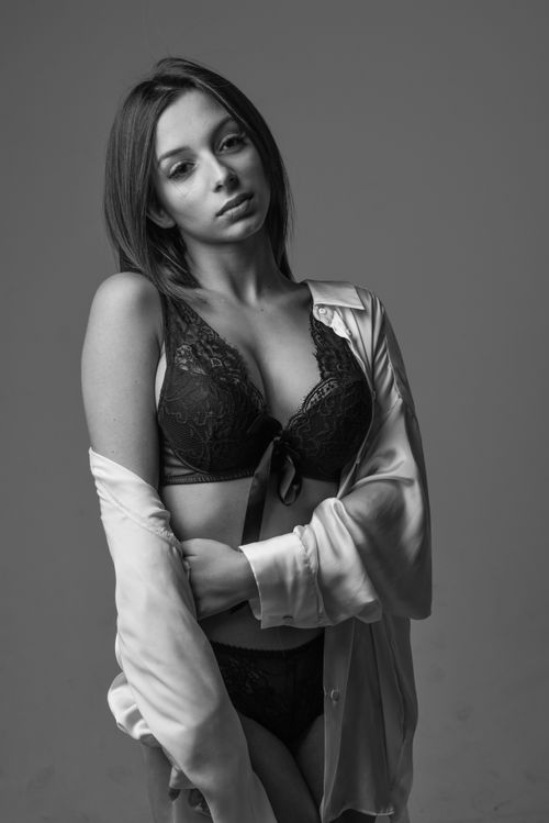 Free Black and white portrait of a woman posing in lingerie during a studio photoshoot. Stock Photo