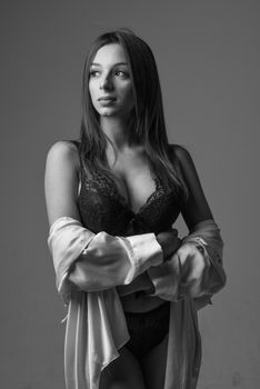 Monochrome studio portrait of a woman in lingerie, exuding confidence and grace.