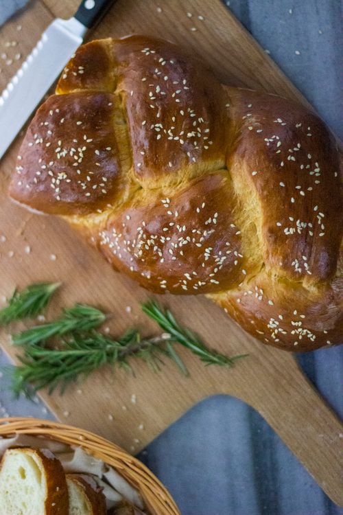 Free Top view of freshly braided challah bread with sesame seeds on cutting board. Stock Photo