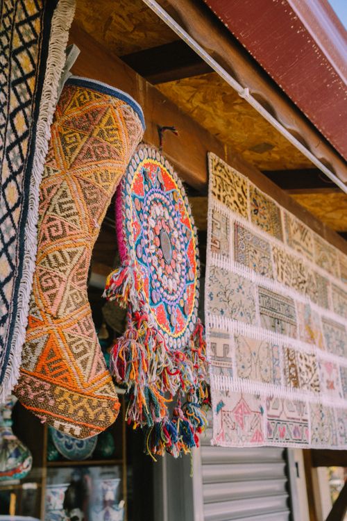 Free Colorful tapestry with intricate patterns displayed in an outdoor market scene. Stock Photo