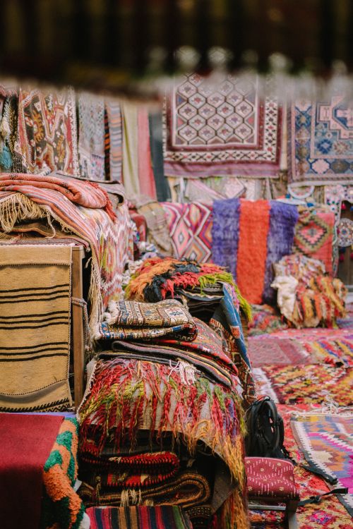 Free Vibrant handmade rugs and textiles on display in a lively bazaar setting. Stock Photo